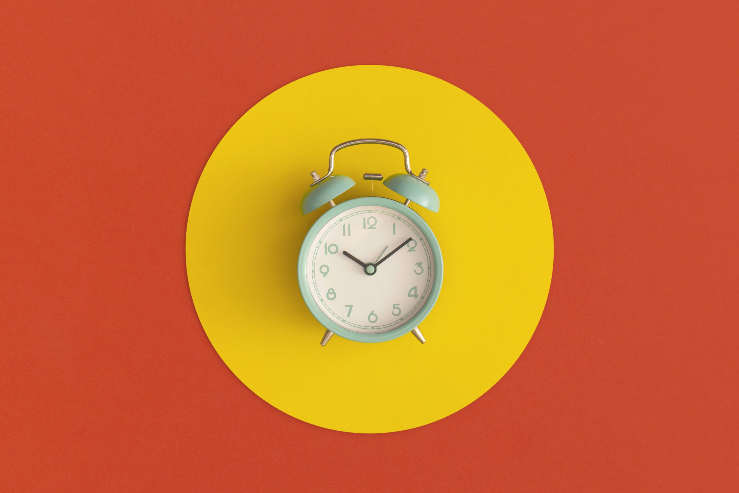 Blue alarm clock on color background. Top view with copy space. Flat lay. Back to school concept.